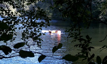 people swimming with a raft in the lake